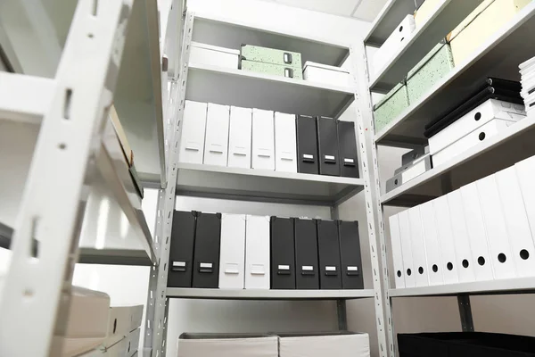 Pastas e caixas com documentos em prateleiras em arquivo, vista de baixo ângulo — Fotografia de Stock