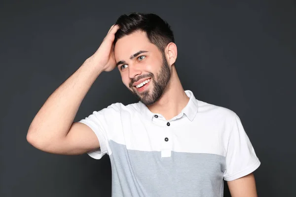 Retrato de belo homem sorridente em fundo cinza — Fotografia de Stock