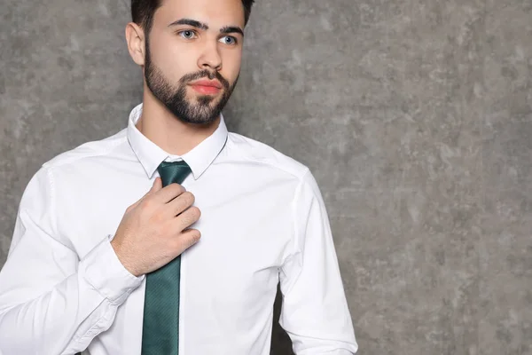 Retrato de hombre de negocios enderezando corbata sobre fondo gris, primer plano. Espacio para texto —  Fotos de Stock