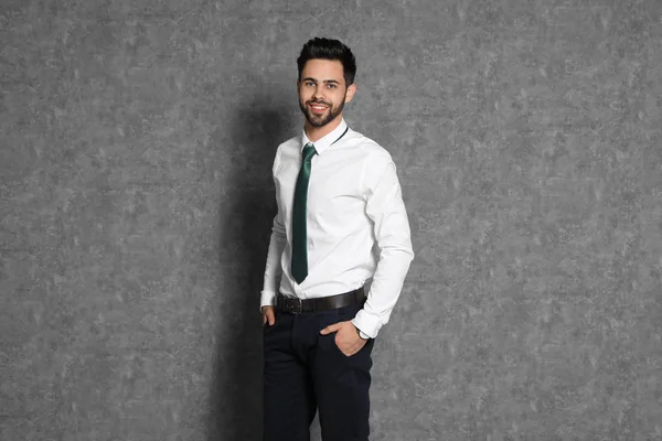 Portret van zelfverzekerde zakenman lachend op grijze achtergrond — Stockfoto