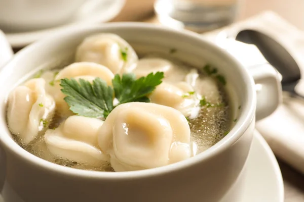 Skål med läckra dumplings i buljong på bordet, närbild. Utrymme för text — Stockfoto