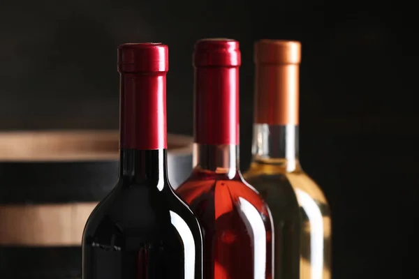 Láhve různého vína na tmavém pozadí, v šatně. Místo pro text — Stock fotografie