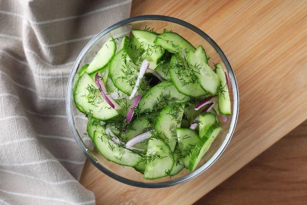 Schüssel mit leckerem Gurkensalat auf Holztisch serviert, flach gelegt — Stockfoto