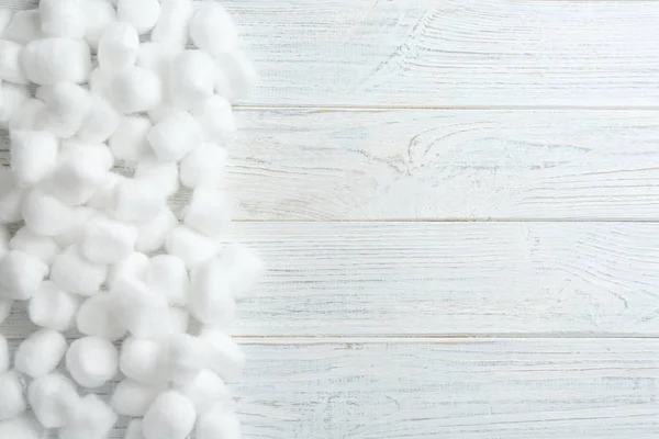 Muchas bolas de algodón y espacio para el texto sobre fondo de madera blanca, vista superior — Foto de Stock