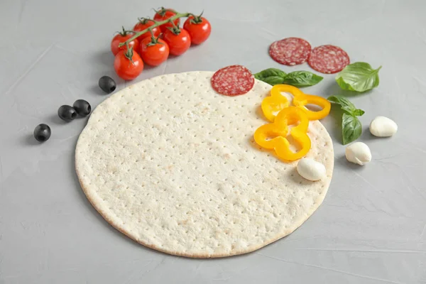 Base e ingredientes para pizza en mesa ligera — Foto de Stock