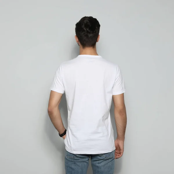 Young man in t-shirt on light background. Mock up for design — Stock Photo, Image