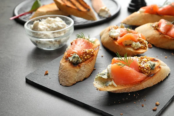 Tasty bruschettas with salmon and blue cheese served on table. Space for text — Stock Photo, Image