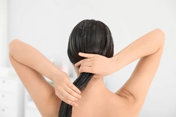 Woman applying hair conditioner in light bathroom — Stock Photo, Image