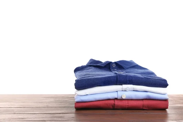 Pile of ironed clothes on table against white background. Space for text — Stock Photo, Image