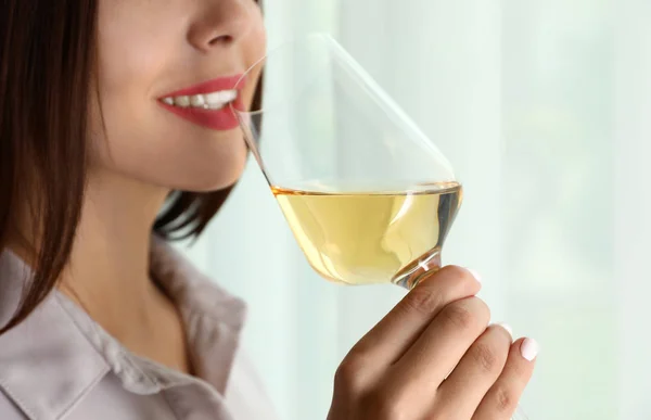 Young woman with glass of luxury white wine indoors, closeup. Space for text