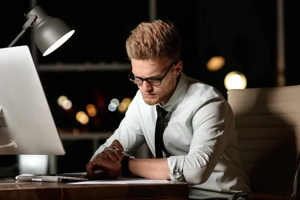 Joven trabajando en la oficina por la noche —  Fotos de Stock