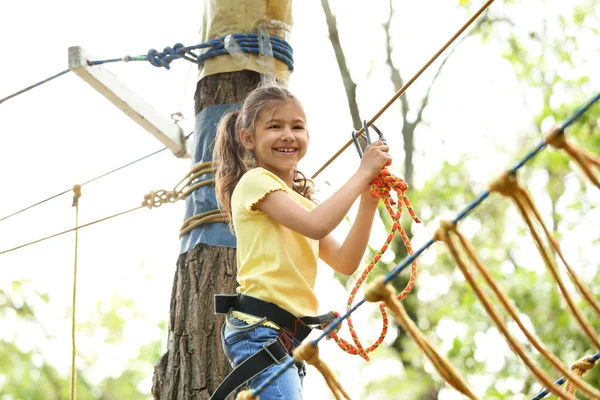 Niña escalando en el parque de aventuras. Campamento de verano — Foto de Stock