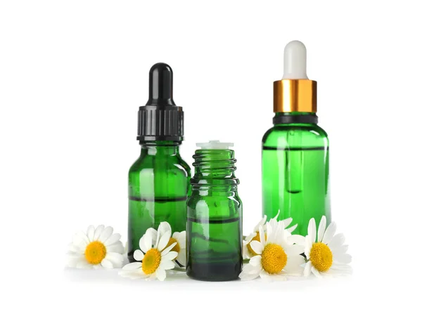 Garrafas de óleo essencial de ervas e flores de camomila isoladas em branco — Fotografia de Stock