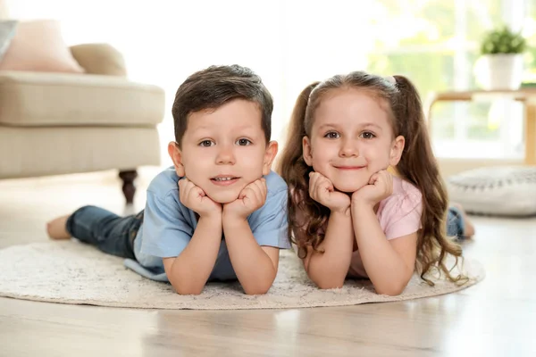 Oturma odasında halı üzerinde yatan sevimli çocuklar — Stok fotoğraf