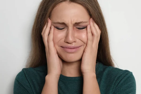 Mujer joven llorando sobre fondo claro. Alto a la violencia —  Fotos de Stock