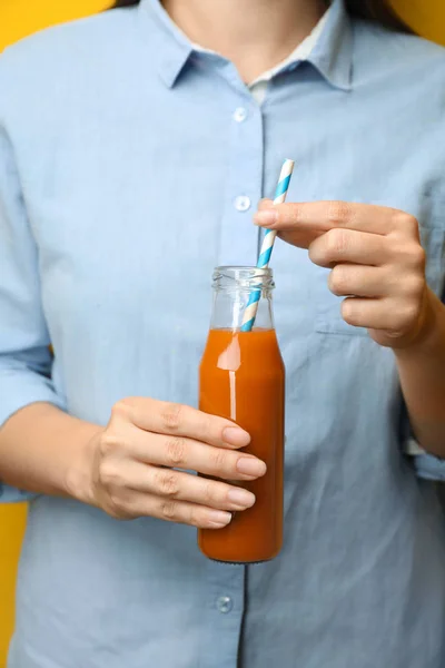 Женщина держит бутылку вкусного морковного сока, крупным планом — стоковое фото