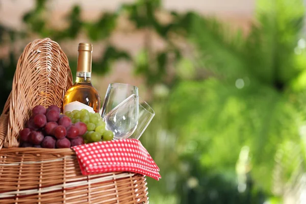 Piknikkosarat borral, poharakkal és szőlőkkel, elmosódott háttérrel, hely a szöveghez — Stock Fotó