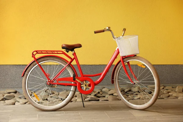 Nowoczesna kolorowa rower z koszykiem w pobliżu ściany na zewnątrz — Zdjęcie stockowe