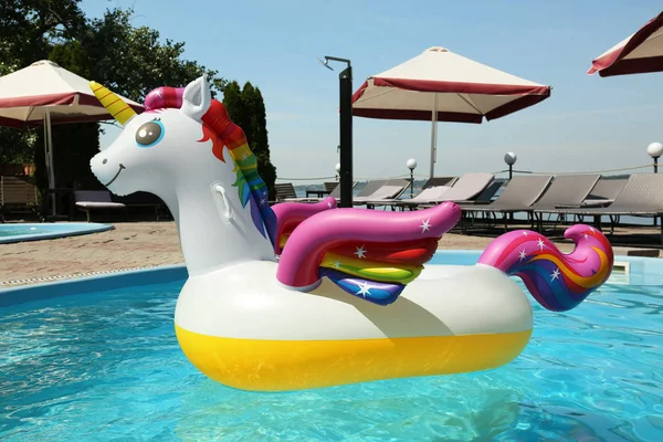 Komik şişme tek boynuzlu at halka güneşli bir günde yüzme havuzunda yüzen, açık havada — Stok fotoğraf