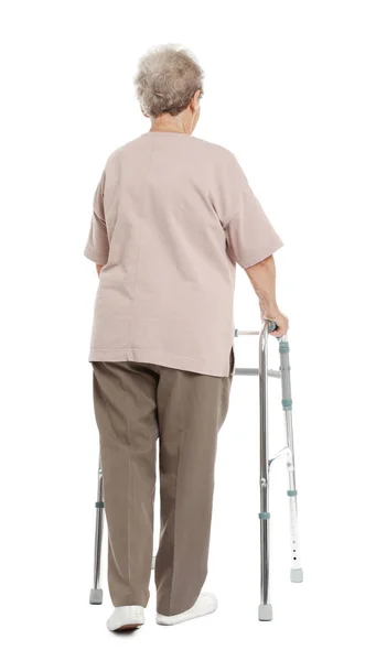 Ηλικιωμένη γυναίκα χρησιμοποιώντας το πλαίσιο περπατήματος απομονωμένη σε λευκό, πίσω όψη — Φωτογραφία Αρχείου