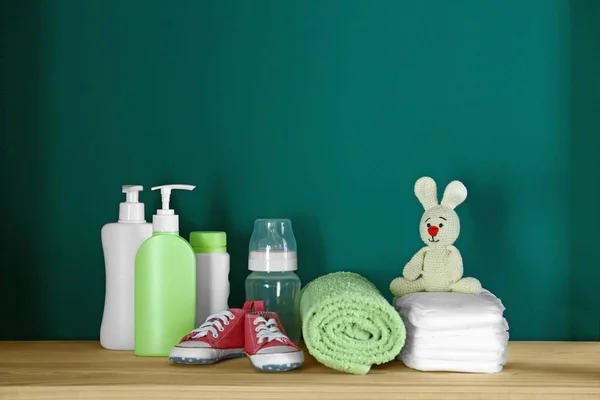 청록색 벽 근처 나무 테이블에 아기 방 인테리어 욕실 액세서리 및 장난감 — 스톡 사진