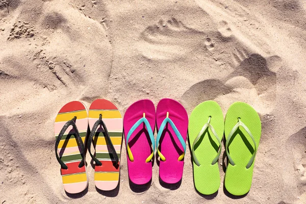 Επίπεδη σύνθεση με σαγιονάρες στην άμμο το καλοκαίρι, Χώρος για κείμενο. Αξεσουάρ παραλίας — Φωτογραφία Αρχείου