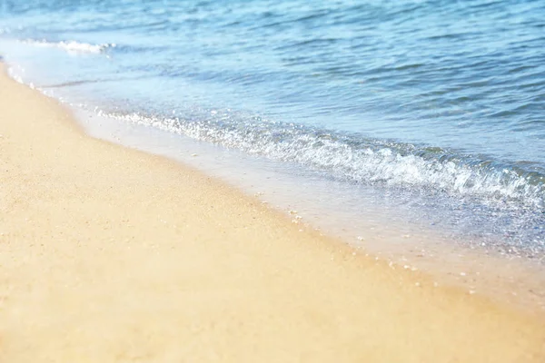 Вид на морську воду і пляжний пісок у сонячний день — стокове фото