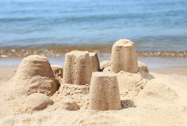 Pequenas figuras de areia na praia perto do mar — Fotografia de Stock