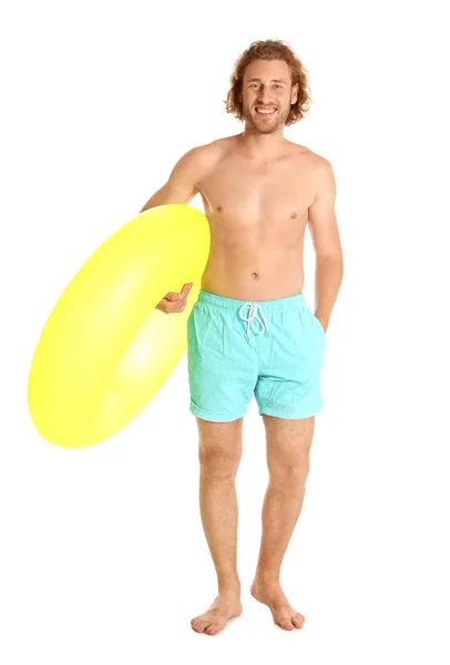Привлекательный молодой человек в купальниках с желтым надувным кольцом на белом фоне — стоковое фото