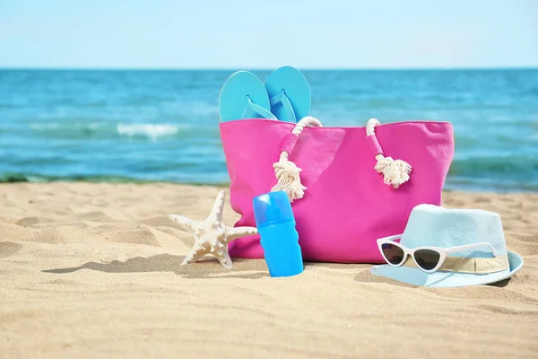 Accessoires de plage élégants sur sable près de la mer. Espace pour le texte — Photo