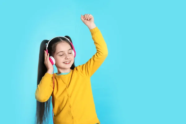 可爱的女孩享受音乐在彩色背景的耳机。文本空间 — 图库照片