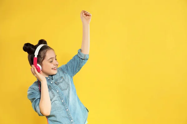 Cute Girl korzystających muzyki w słuchawkach na kolorowym tle. Miejsce na tekst — Zdjęcie stockowe