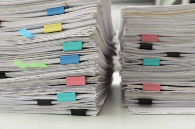 Ofis masasında ataç içeren belge yığınları, yakın çekim