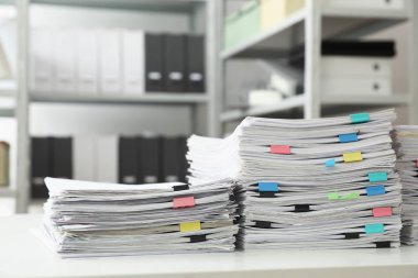 Ofis masasında kağıt kliplere sahip belgelerin yığınları