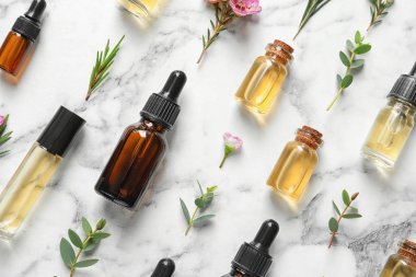 Beyaz mermer arka plan üzerinde doğal çay ağacı yağı şişeleri ile Düz yatıyordu kompozisyon