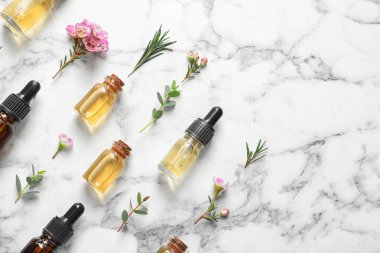 Beyaz mermer arka planda metin için doğal çay ağacı yağı ve boşluk şişeleri ile düz yatıyordu kompozisyon