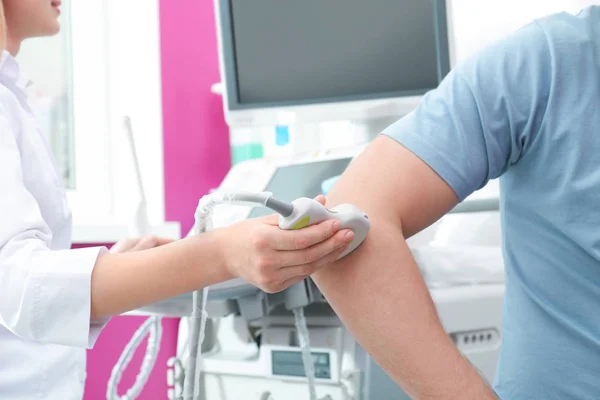 Doctor conducting ultrasound examination of elbow joint in clinic, closeup — Stock Photo, Image