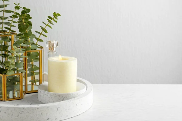 Κομψό προσφορά σύνθεση με κάψιμο κερί και φυτά σε λευκό ξύλινο τραπέζι κατά φως φόντο, Χώρος για το κείμενο. Άνετο εσωτερικό στοιχείο — Φωτογραφία Αρχείου