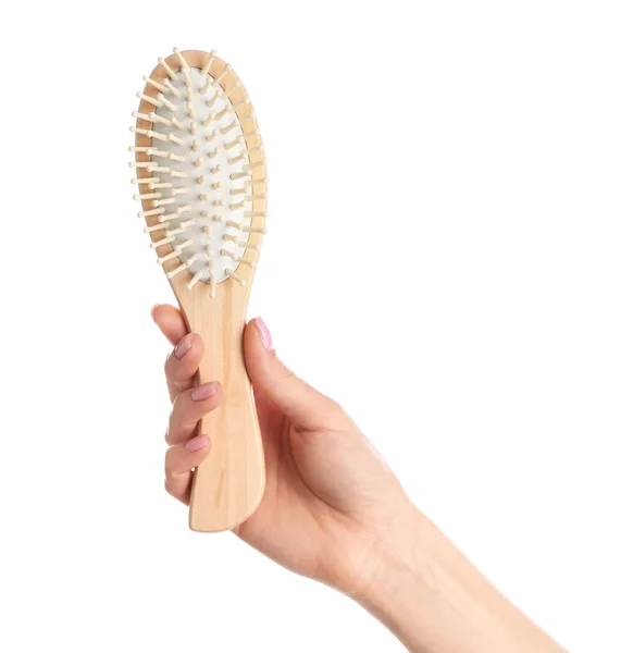 Femme tenant une brosse à cheveux en bois sur fond blanc, gros plan — Photo