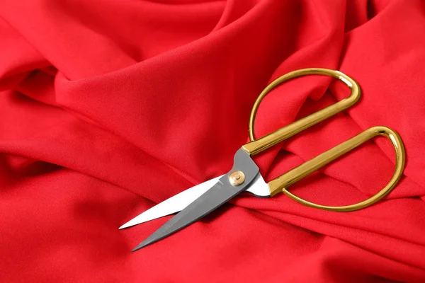Острые ножницы на красной ткани, место для текста. Аксессуары для одежды — стоковое фото