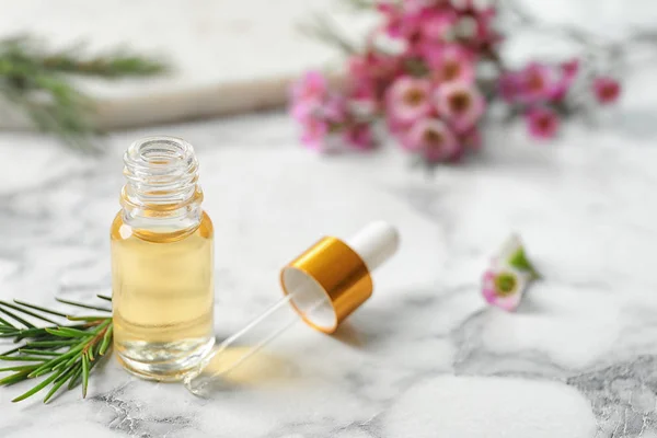 Composição com garrafa de óleo de árvore de chá natural na mesa de mármore branco. Espaço para texto — Fotografia de Stock