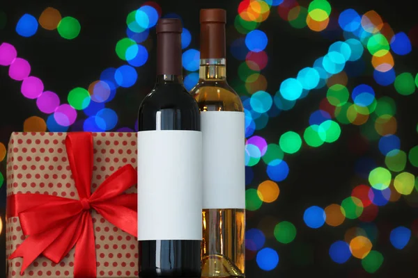 Caja de regalo con y botellas de vino en la mesa contra luces borrosas, espacio para el texto. Efecto Bokeh — Foto de Stock