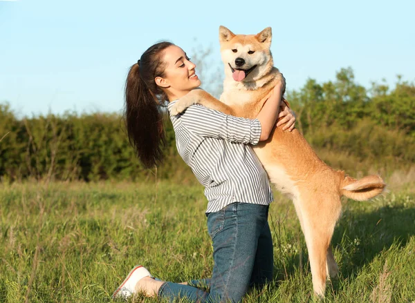 Junge Frau mit entzückendem Akita-Inu-Hund im Park — Stockfoto