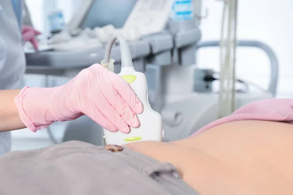 Doktor, který provádí ultrazvukovou prohlídku břicha pacienta na klinice, zaostřená — Stock fotografie