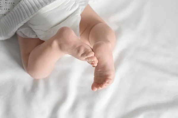 Kleines Baby mit niedlichen Füßen auf Bettlaken, über der Ansicht. Raum für Text — Stockfoto