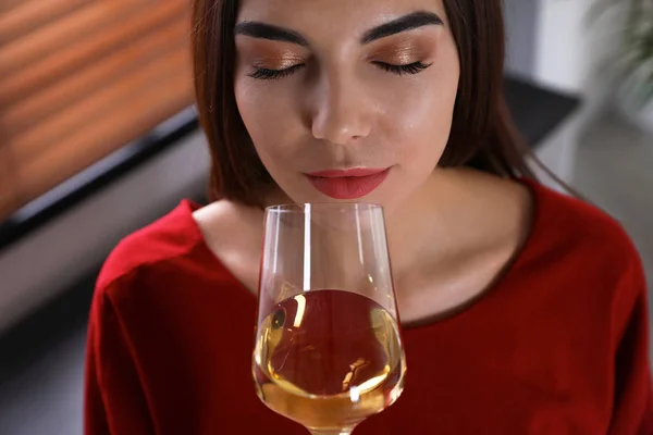 Красивая молодая женщина с бокалом роскошного белого вина в помещении, вид крупным планом — стоковое фото