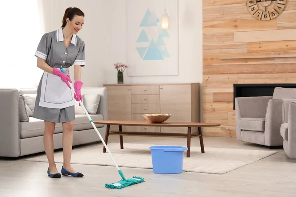 Η καμαριέρα πλένει το πάτωμα με σφουγγαρίστρα στο δωμάτιο του ξενοδοχείου. Χώρος για κείμενο — Φωτογραφία Αρχείου