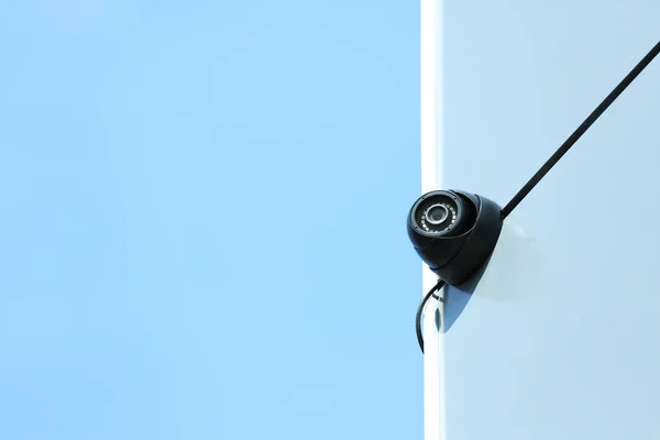 Moderne CCTV-bewakingscamera op de muur buitenshuis. Ruimte voor tekst — Stockfoto