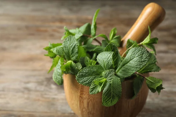 Trämur bruk med fräsch grön mynta på bordet, närbild. Utrymme för text — Stockfoto