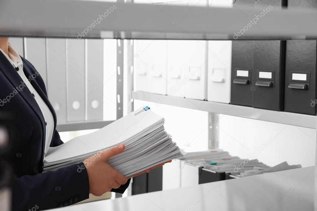 Female worker with documents in office, closeup. Space for text